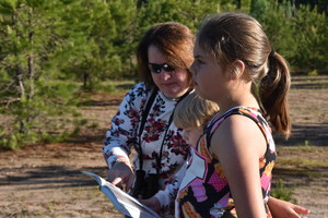 Ga. State Representative Regina Quick and a SJES student look up a bird that they have just spotted.